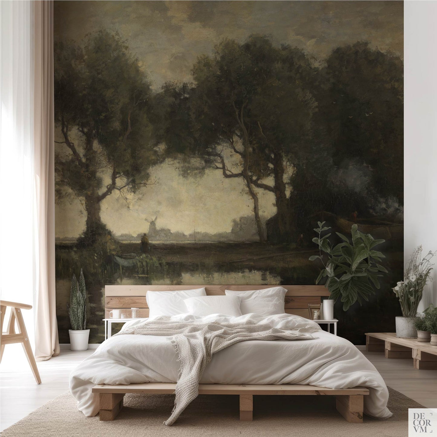 Moody countryside landscape wallpaper mural behind a natural wood platform bed with white bedding, sheer curtains, and potted plants — earthy boho bedroom accent wall