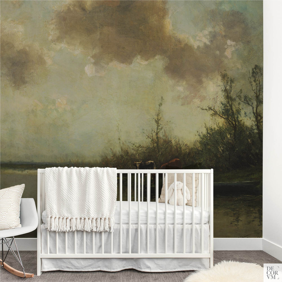 Pastoral cows on a riverbank wallpaper mural in a nursery with white crib and rocking chair