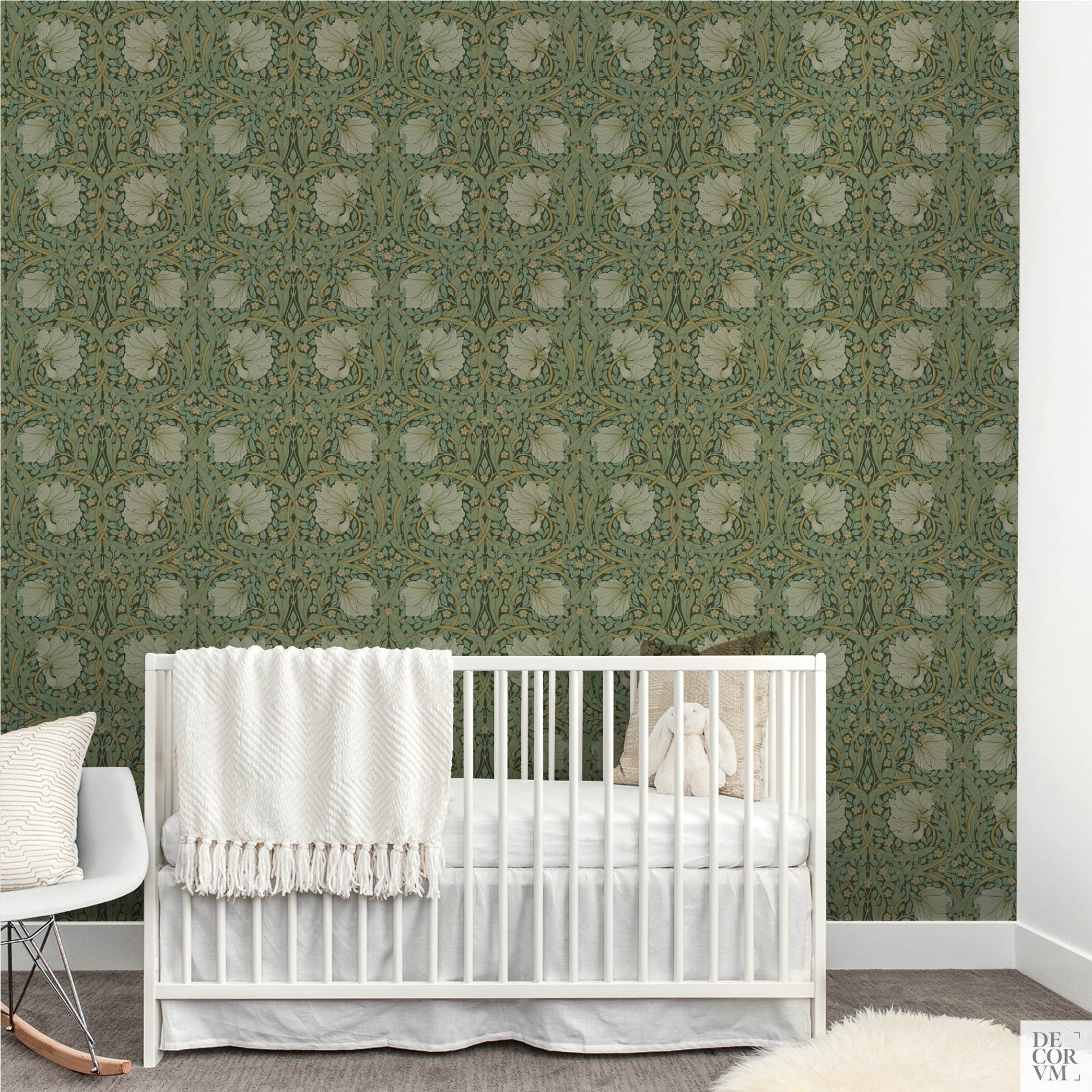 Nursery room setup with a white crib placed directly in front of the William Morris Pimpernel Wallpaper Mural — Sage Arts & Crafts Decor, with a white rocking chair to the left.