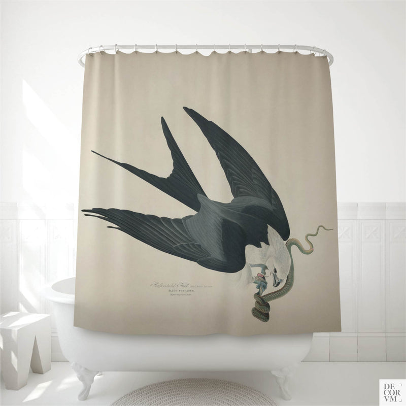 Swallow-tailed hawk shower curtain displayed in a white bathroom — dramatic bird in mid-flight seizing a snake, dark blue-black plumage and deeply forked tail against a warm muted background.