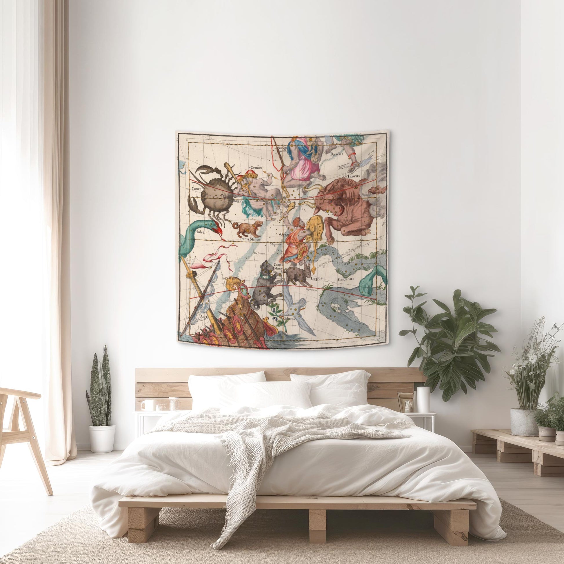 Orion and Taurus celestial map tapestry hung above a wooden platform bed with white linens and indoor plants.