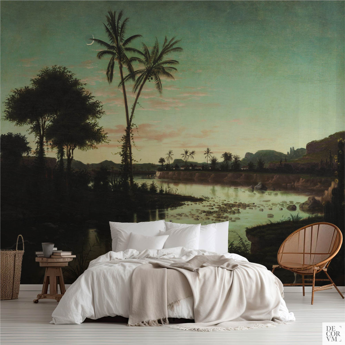 Bedroom scene featuring the Tropical Twilight Palms Wallpaper Mural — Vintage Tropical Decor behind a bed with white linens, a wooden stool, and a rattan chair on the right.