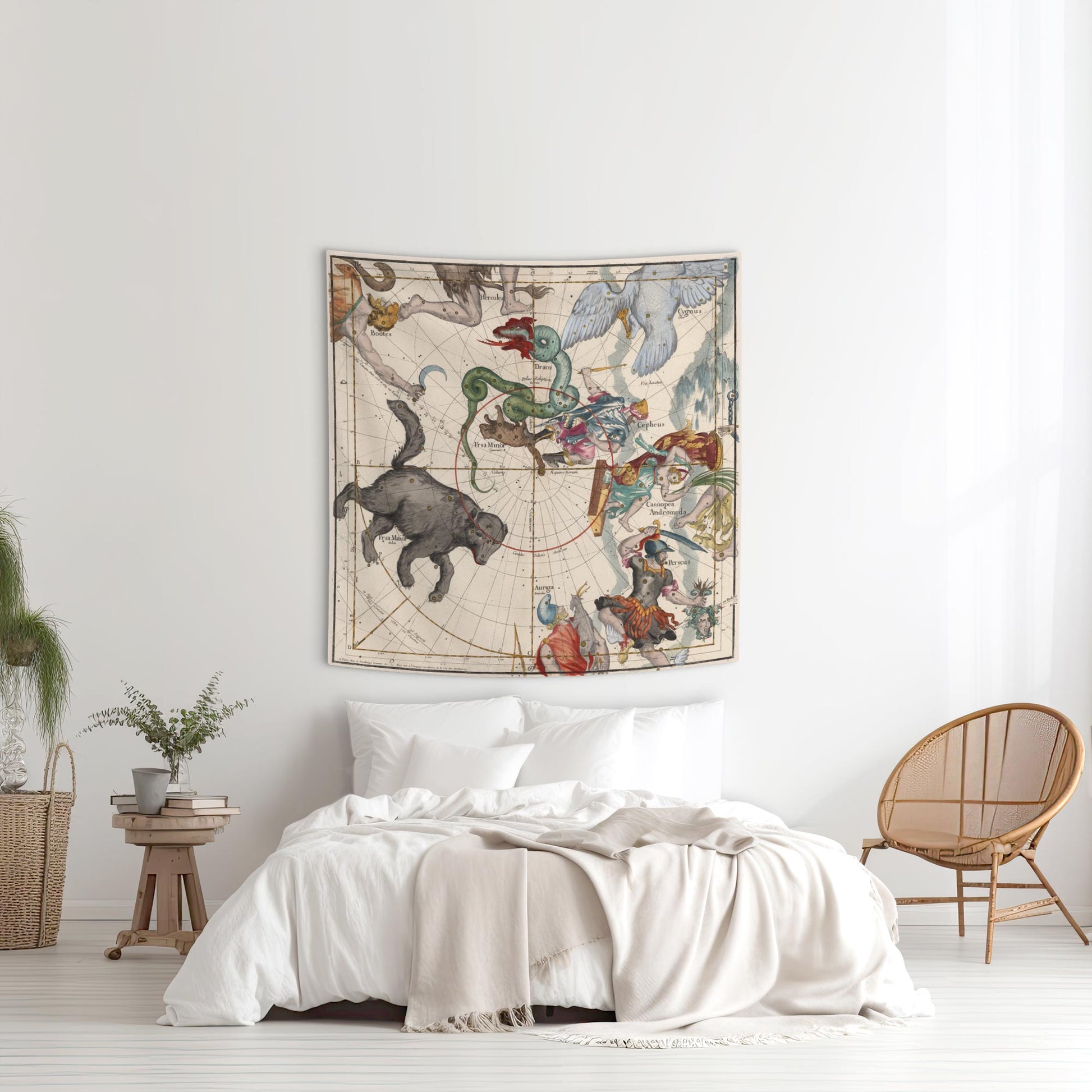A bright, airy bedroom featuring a historic Ursa Major and Perseus star chart tapestry hanging elegantly above a bed with white linens, styled with a natural wicker chair and a rustic side table.