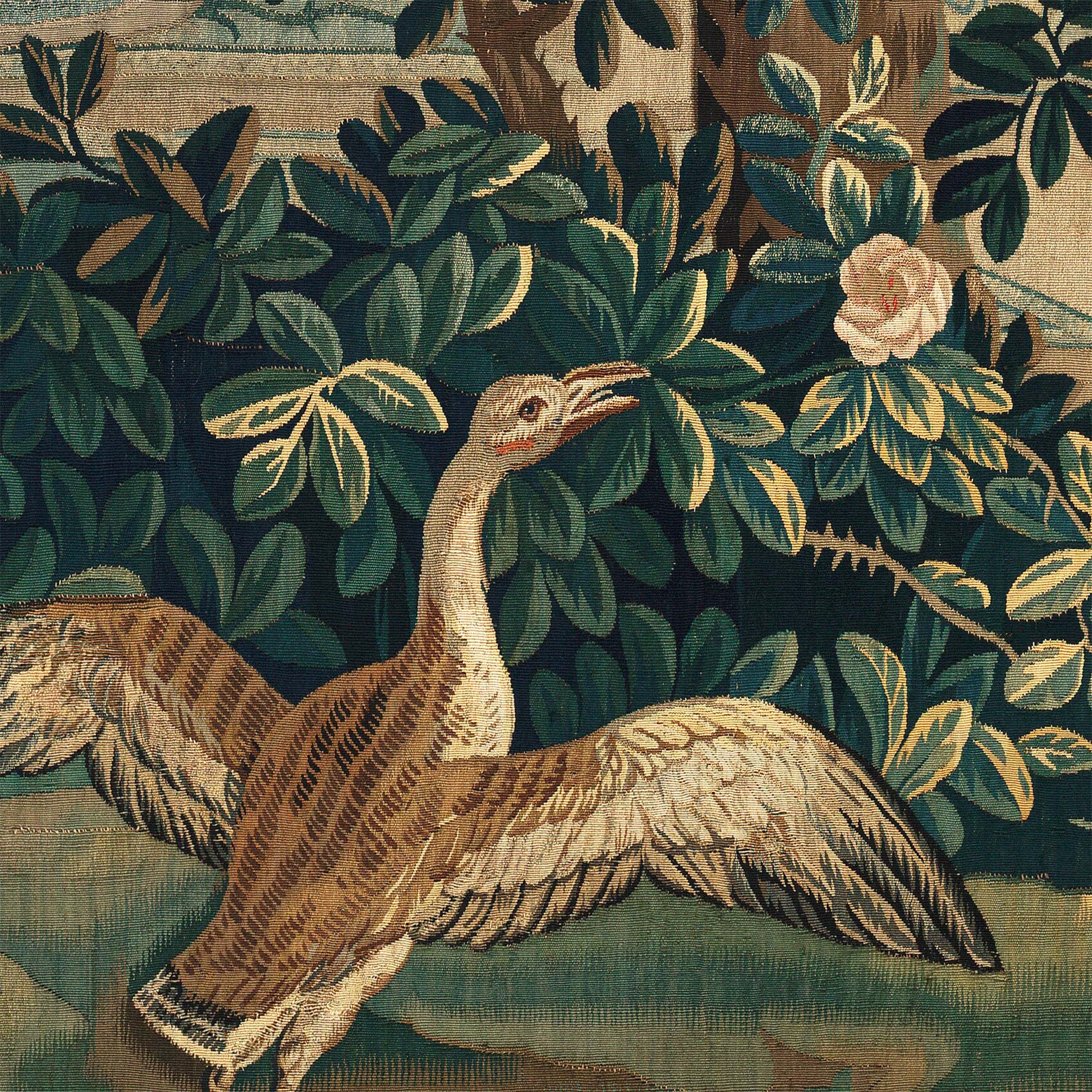 Brown bird with outstretched wings on a grassy lawn beside a pink rose — design detail from the 18th-century French verdure chateau garden.
