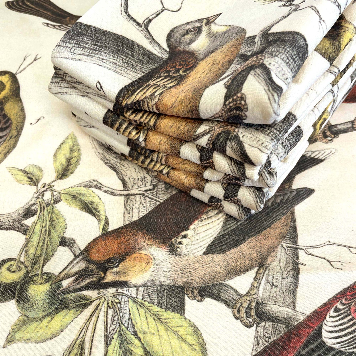 Folded stack of vintage finches cushion covers showing the Victorian bird engraving on cotton-polyester fabric.