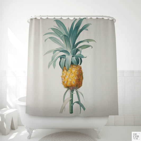 Vintage pineapple shower curtain hung over a white clawfoot tub in a bright bathroom — a 19th-century French botanical print of Bromella ananas printed on soft cream fabric by Decorvm.