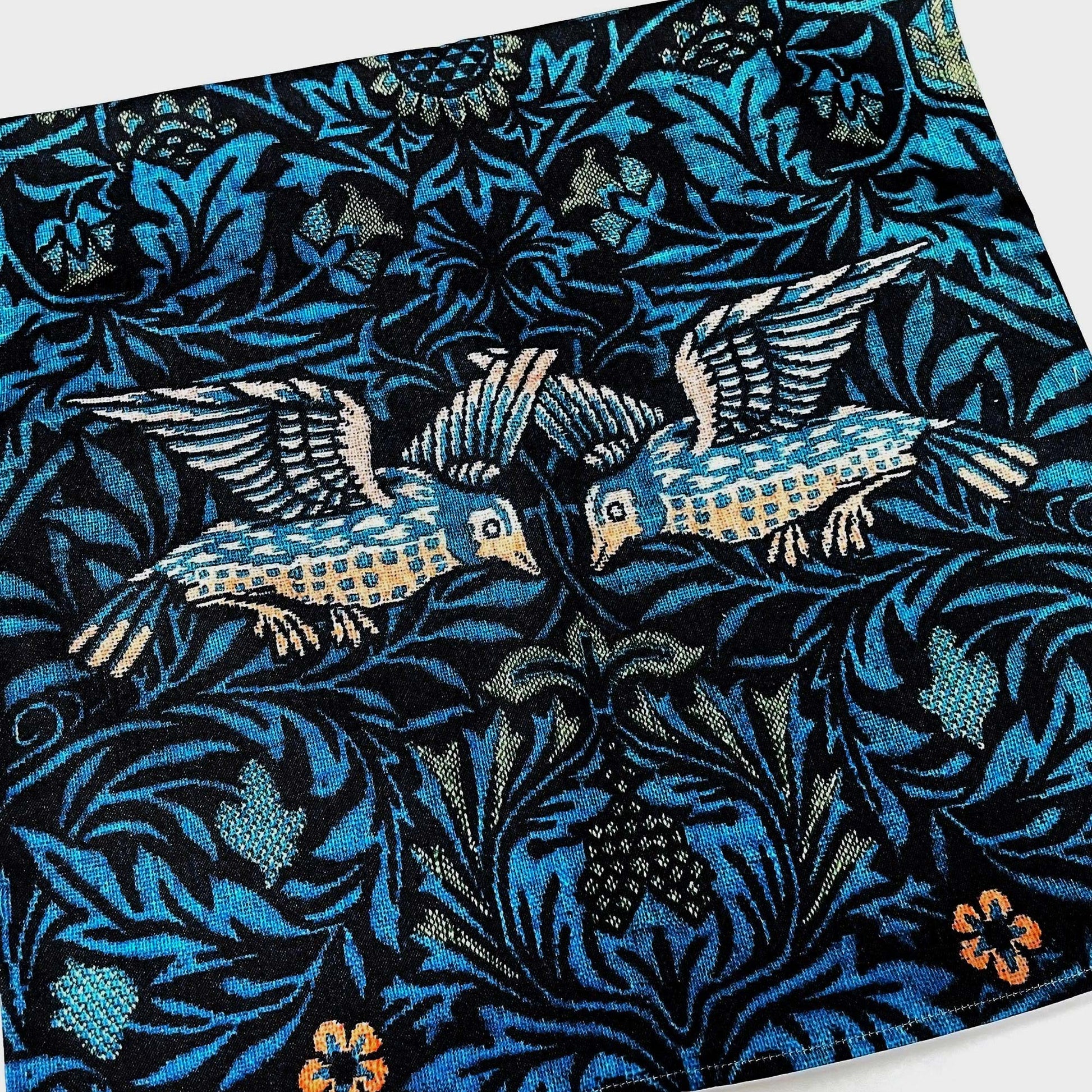 Close-up of the William Morris Birds pillow cover showing two birds facing each other across the dark foliate ground.