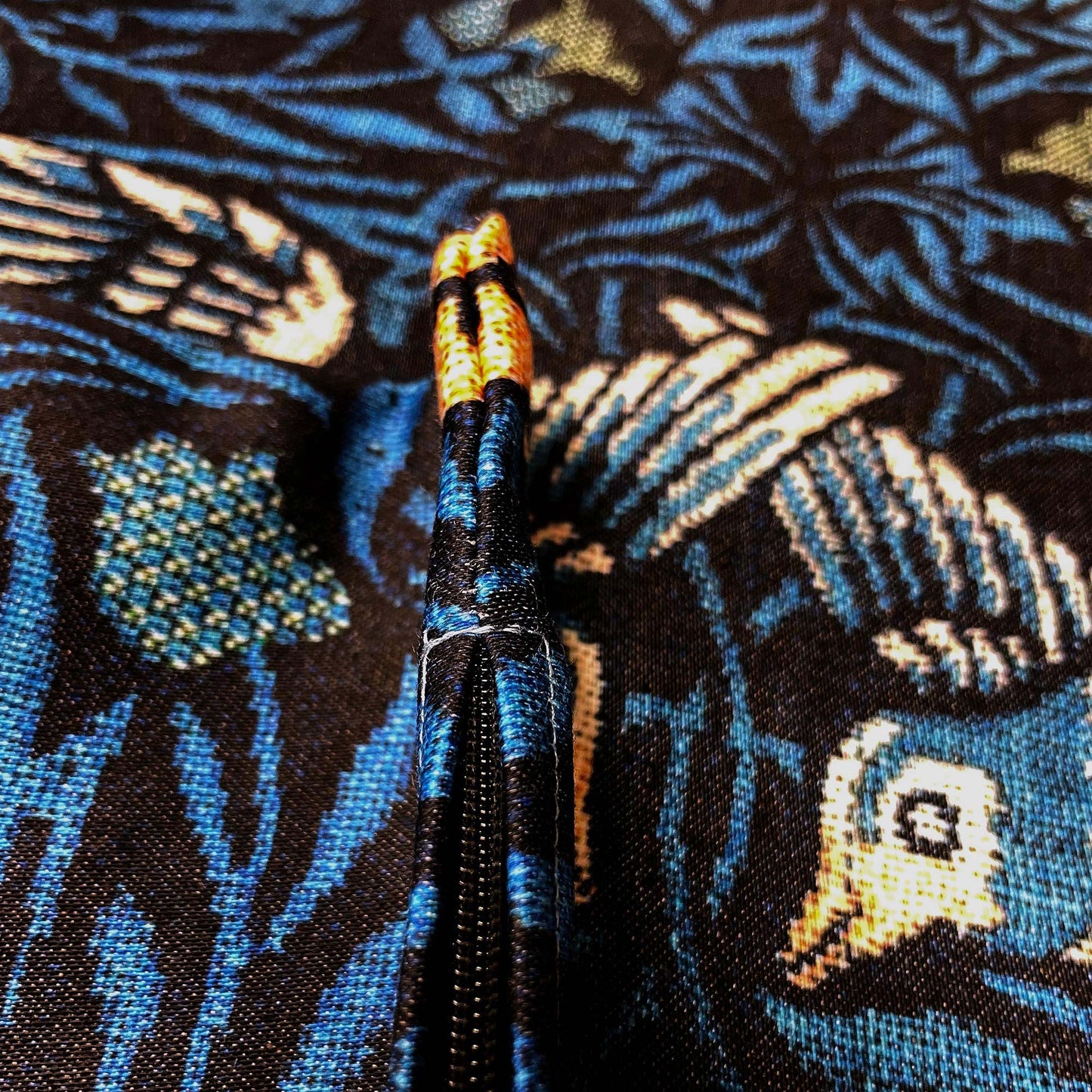 Edge of the William Morris Birds pillow cover showing the seam stitching and zipper hardware.