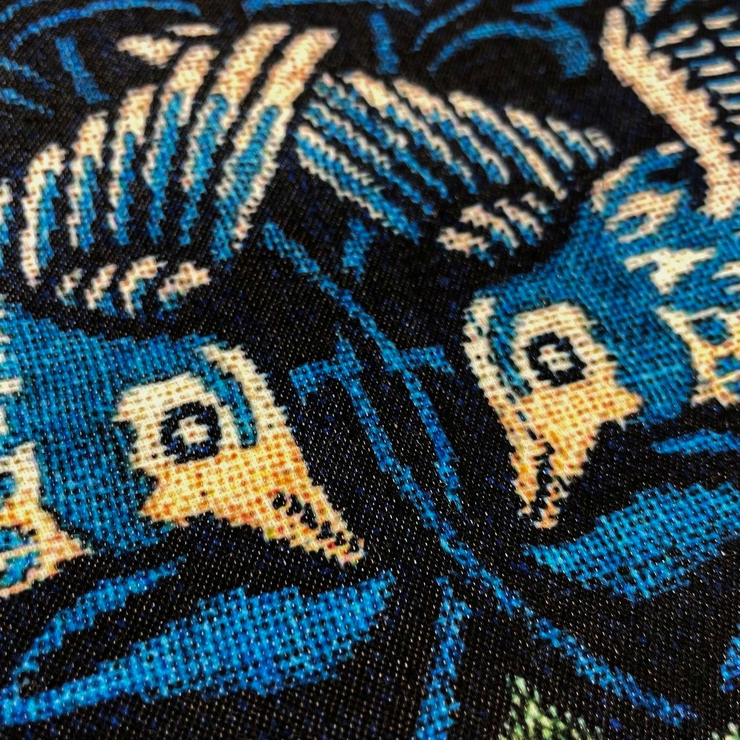 Macro of the two birds' heads against navy and teal foliage — design detail from William Morris's Birds pattern.