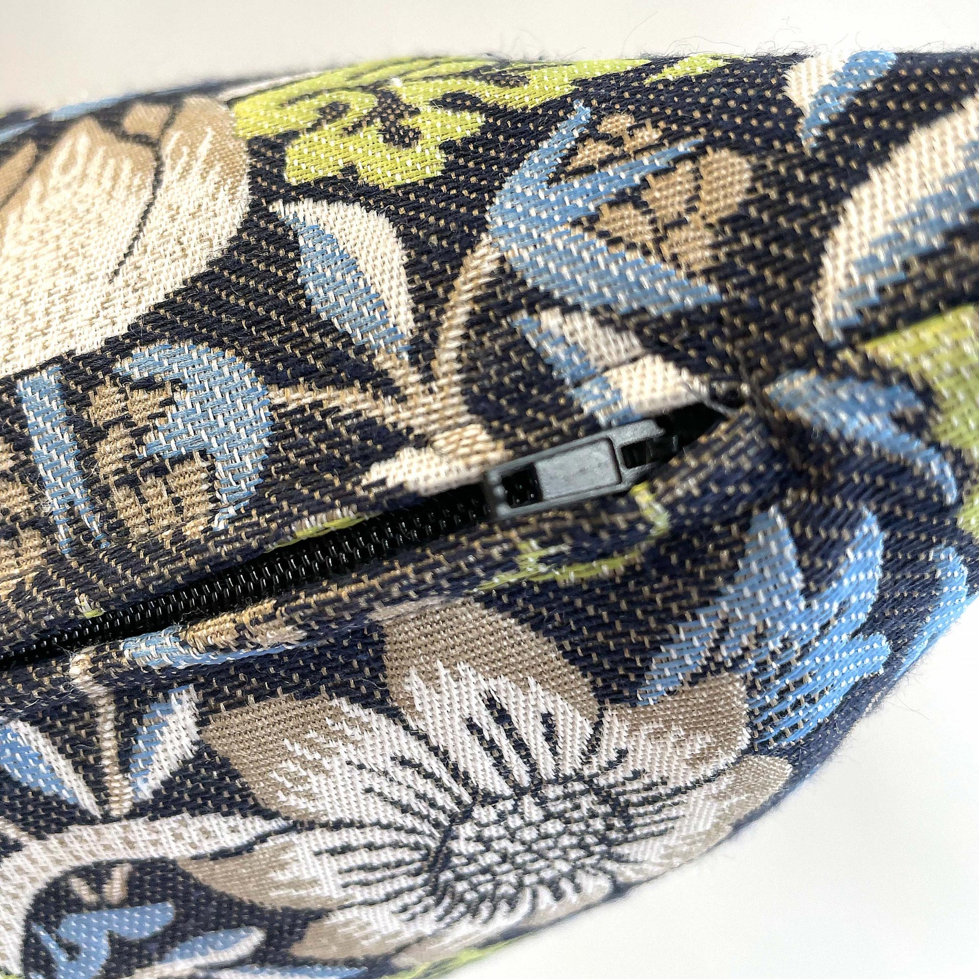 Zipper slider and side seam on the William Morris Strawberry Thief jacquard pillow cover.