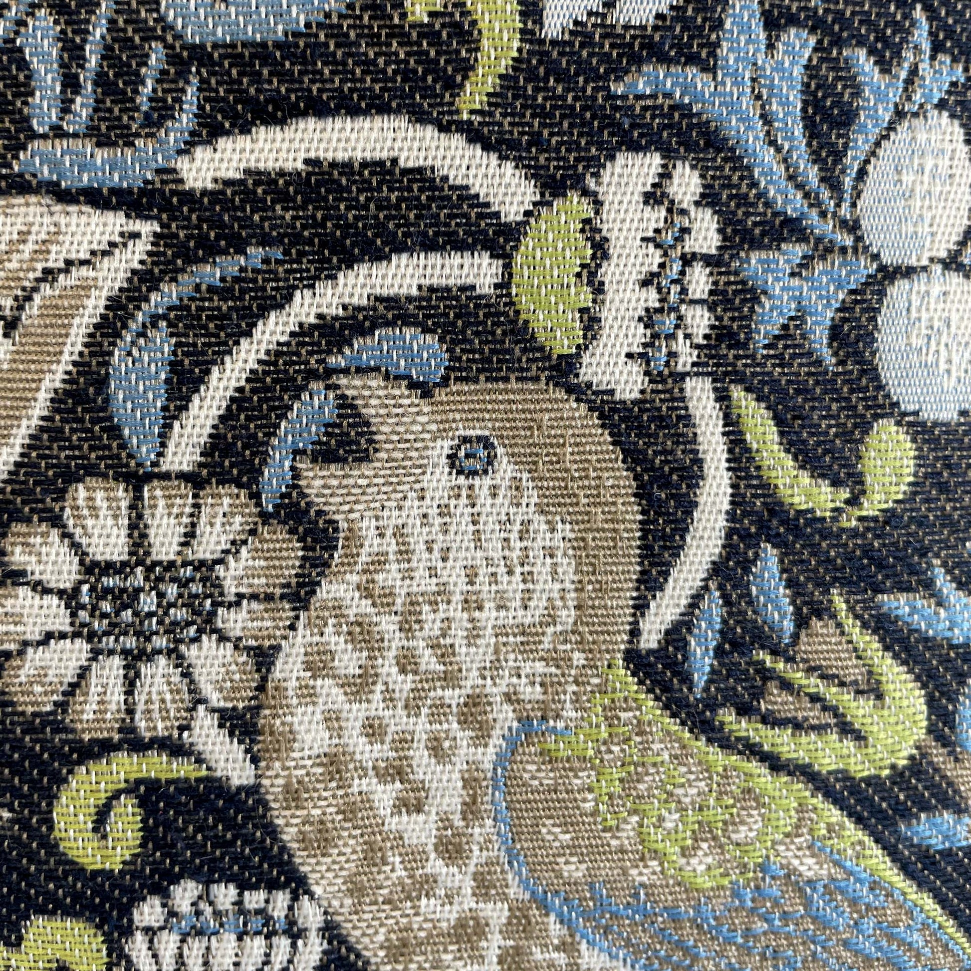 Macro of a woven bird figure — jacquard detail of William Morris's 1883 Strawberry Thief pattern.